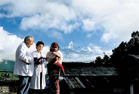2010년 가을 히말라야 끝자락 네팔의 한 마을에서 아이를 안은 주민과 이야기하고 있는 강원희 선교사(왼쪽)와 아내 최화순(가운데) 권사. /사진작가 고천윤(조선일보DB)