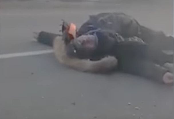 러시아군 공격을 받은 아버지가 길에 쓰러진 채 아들의 안전을 확인하기 위해 고개를 돌리는 모습. /RFE/RL 유튜브