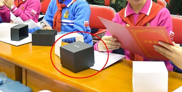 김정은이 조선소년단에 선물한 손목시계 상자 위에 일본 세이코의 패션 워치 브랜드 'ALBA' 문구가 적혀져 있다. /조선중앙통신 연합뉴스