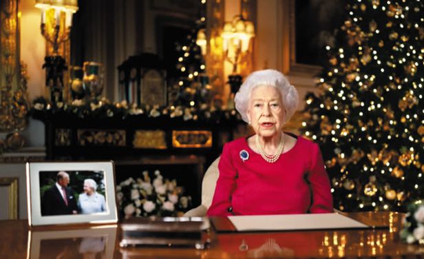 25일(현지 시각) 엘리자베스 2세 영국 여왕이 사전 녹화한 TV 영상을 통해 크리스마스 메시지를 전하고 있다. 여왕 왼쪽에 놓인 사진은 지난 4월 세상을 떠난 남편 필립 공과 2007년 결혼 60주년을 기념해 찍은 것이다. /BBC