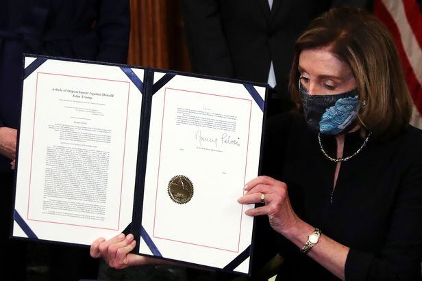 낸시 펠로시(D-CA) 미국 하원의장이 13일 워싱턴 의사당에서 열린 취임식에서 도널드 트럼프 미국 대통령에 대한 탄핵소추안에 서명하고 난 뒤 이를 보여주고 있다. /로이터 연합뉴스
