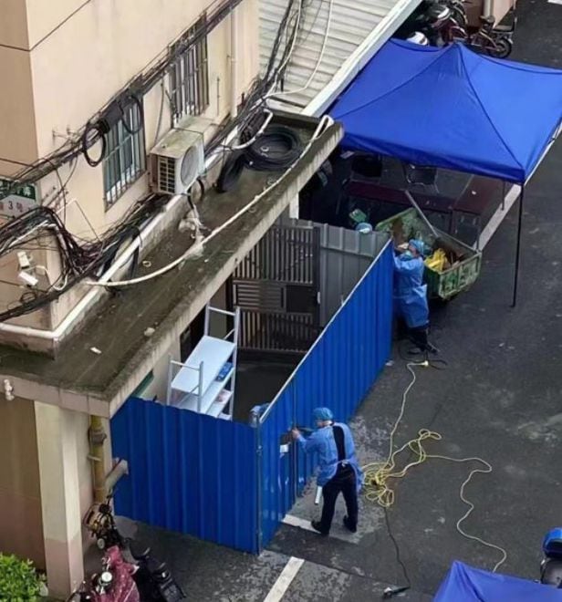 중국 방역당국 관계자들이 상하이의 한 아파트 입구에 푸른색 철제 펜스를 설치하고 있다./트위터