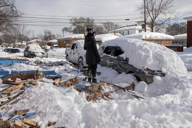 16일(현지시각) 시카고에서 한 시민이 눈 폭풍에 건물이 무너지면서 파손된 자신의 차량을 쳐다보고있다./AP 연합뉴스
