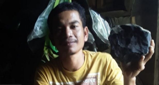 조슈아 후타가룽(33)이 지난 8월 인도네시아 수마트라섬의 자신의 집 마당에서 발견한 운석을 들고 있다. /트위터
