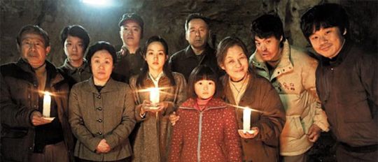 북한 인권 문제를 다룬 영화 ‘신이 보낸 사람’에 나오는 북한 지하 교회 교인들이 촛불을 들고 서 있는 모습을 사진 찍고 있는 장면. 같이 개봉한 ‘로보캅’의 절반에도 미치지 못하는 전국 221개 스크린에서 상영을 시작했지만 ‘신이 보낸 사람’은 14~16일 좌석 점유율 49%를 기록하며 조용한 흥행 돌풍을 일으키고 있다