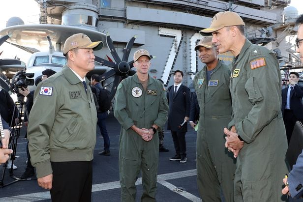 신원식 국방부 장관이 22일 부산 남구 해군작전사령부 부산작전기지에 입항한 미국 제1항모강습단의 칼빈슨함을 방문해 제1항모강습단장 카를로스 사르디엘로 준장과 대화하고 있다. /국방부