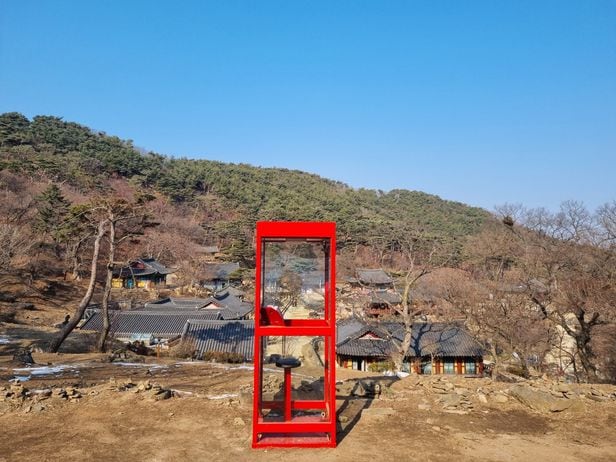 고려시대 가궐지에 놓인 빨간 공중전화 부스. 전등사 전경이 가장 잘 보이는 곳에 상징물처럼 서있다. /김한수 기자