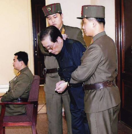 2013년 12월 13일자 북한 노동신이 보도한 사진. 양 손을 포승줄에 묶인 장성택이 국가안전보위부원들에게 잡힌 채 법정에 서 있다. /노동신문