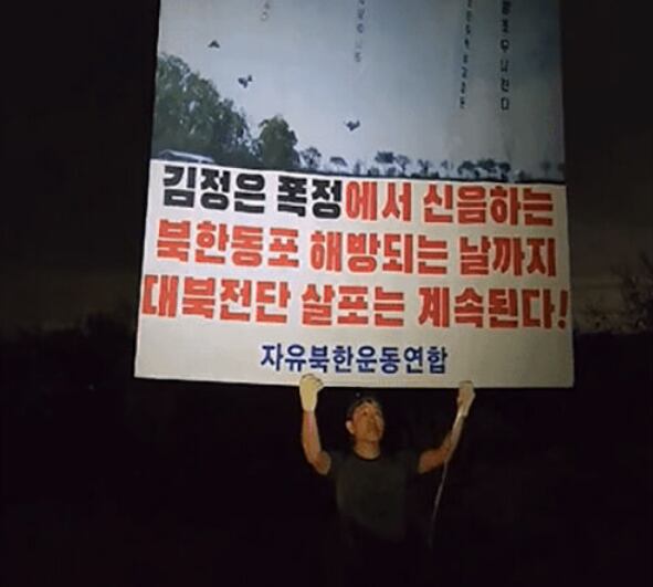 자유북한운동연합 박상학 대표가 20일 오후 11시쯤 인천 강화도에서 대북 전단이 달린 대형 풍선을 들고 있다. /자유북한운동연합
