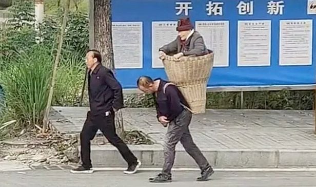 가  중국 남서부 충징시의 한 도로에서  큰 대나무 바구니에 89세 어머니를 넣어 병원으로 향하는 첸 추안(58)과 첸 리(55) 형제/텐센트망