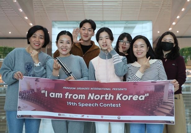 11일 오전 인천국제공항 출국장에서 북한 인권 단체 ‘프리덤 스피커즈 인터내셔널’ 이은구 공동대표와 탈북민 6명이 미 하버드대에서 열릴 영어 말하기 대회 플래카드를 들고 있다. 왼쪽부터 이 대표, 탈북민 이유미·차위성·맹효심·김지은·김명희·이진씨. 탈북민 한 명은 개인 사정으로 따로 출국했다./장련성 기자