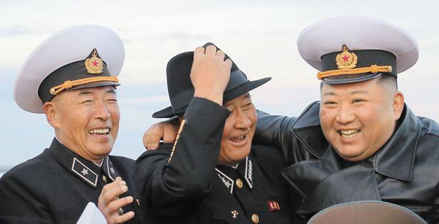 모자 바꿔쓰고 기뻐하는 김정은 - 북한 김정은이 지난 10일 함경남도의 채소 생산 기지를 방문한 모습. 김명식(가운데) 해군사령관과 모자를 바꿔 쓰고 기념 촬영을 하고 있다. /조선중앙통신 연합뉴스