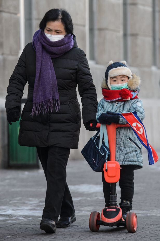 28일(현지 시각) 평양에서 한 여성이 아이의 손을 잡고 걸어가고 있다./AFP 연합뉴스