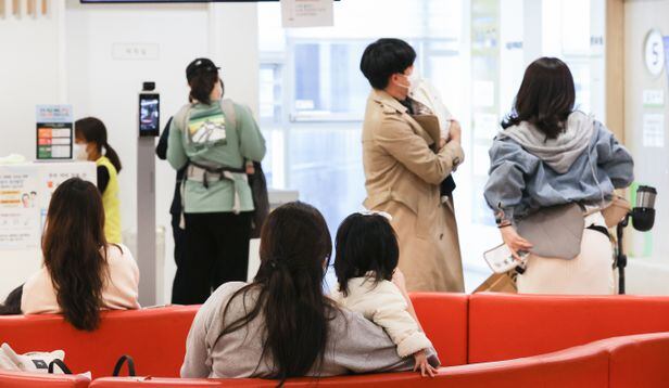 지난 10월 18일 서울 성북구의 한 어린이 병원에서 아이를 안고 온 부모들이 진료를 기다리고 있다./연합뉴스