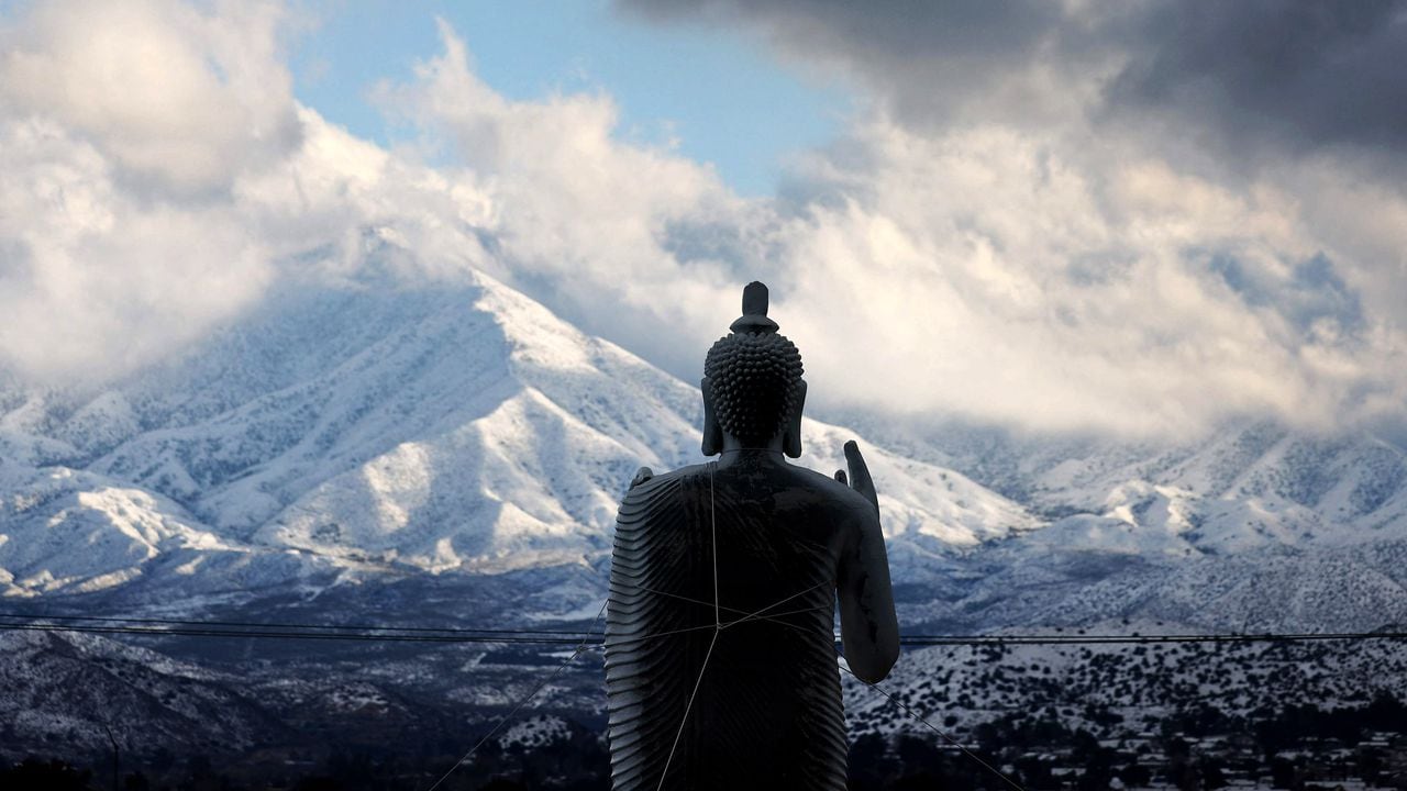 26일 캘리포니아 로스앤젤레스 카운티의 눈 덮인 산 앞에 부처님 동상이 서 있습니다./AFP 연합뉴스