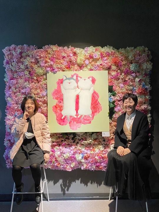 작년 11월 200만원에 판매된 '꽃이불 고양이' 그림 앞에서 앉아있는 김지우씨(왼쪽)와 어머니 신여명씨. /밀알복지재단