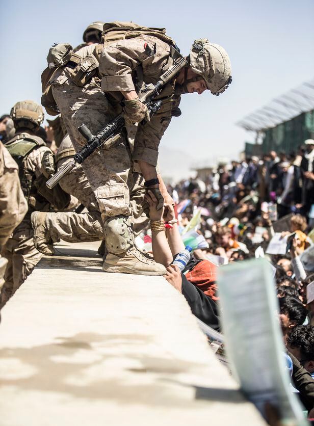 26일(현지 시각) 아프가니스탄 카불의 하미드 카르자이공항에서 미 해병대원이 국외 탈출을 시도하는 사람들을 끌어올리고 있다/미해병대
