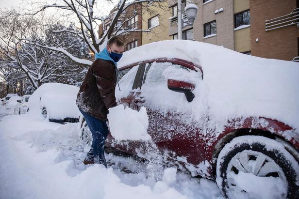 16일(현지시각) 눈폭풍이 내린 시카고에서 한 시민이 차량에 쌓인 눈을 치우고있다./AP 연합뉴스

