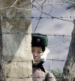 한 북한 여군이 중국 단둥(丹東) 인근 북·중 국경 지역의 북측 초소에서 압록강 넘어 중국쪽을 바라보는 모습. /AP 연합뉴스