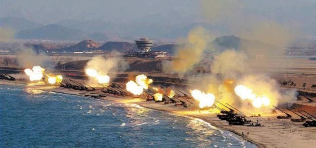 해안가에 배치된 북한 장사정포 수십 문이 일제히 불을 뿜는 모습.
