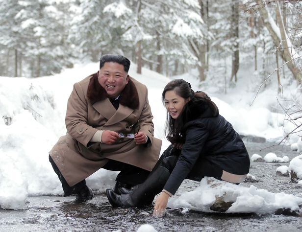 김정은 북한 국무위원장과 부인 리설주가 2019년 12월 군 간부들과 '백두산 혁명지구 전적지'를 돌아보다가 냇가에서 휴식을 취하고 있다. /조선중앙TV·연합뉴스