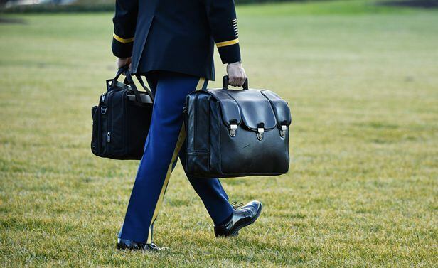 20일 미국의 도널드 트럼프 대통령이 워싱턴 백악관 떠나기 직전 한 군관계자가 군인이 핵가방을 마린 원으로 운반하고 있다./AFP 연합뉴스