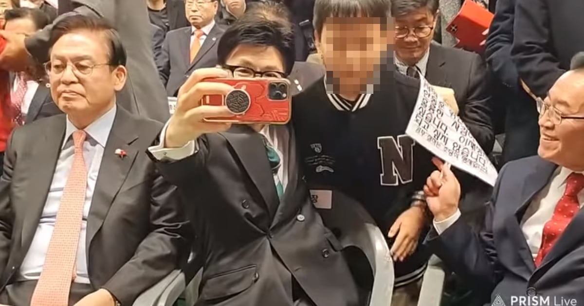 Controversy over Emergency Response Committee Chairman Han Dong-hoon taking a photo holding anti-Lee Jae-myung sign with a child