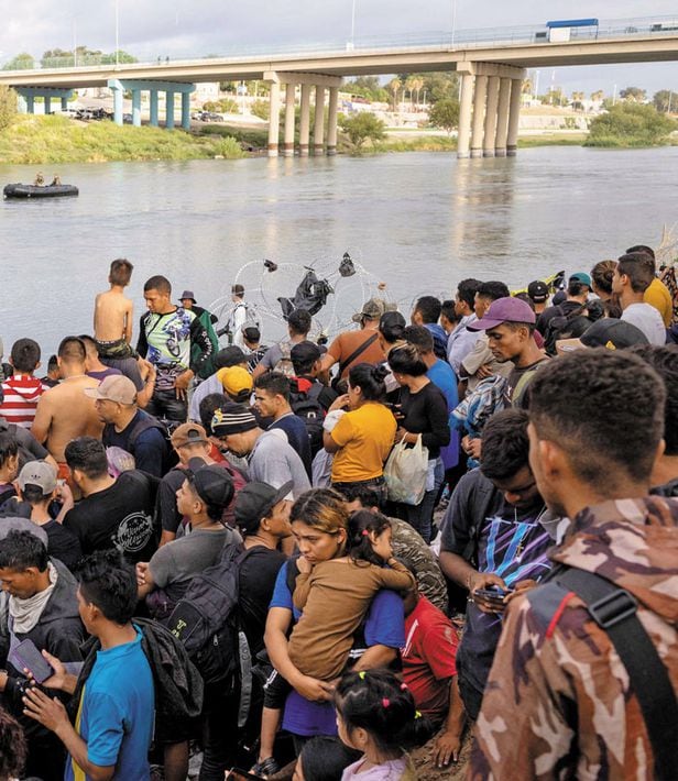 멕시코와 미국 국경을 관통하는 리오그란데강을 건너 미국 텍사스주 남부 도시 이글 패스에 도착한 중남미 이민자들이 지난달 30일(현지 시각) 미 당국의 입국 심사 절차를 기다리고 있다. /AFP 연합뉴스