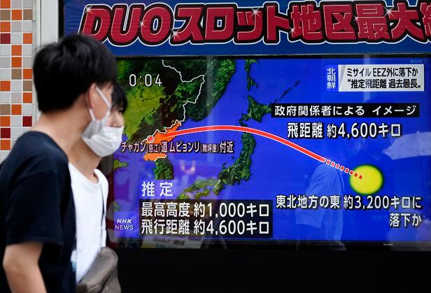 북한이 일본 열도를 통과하는 탄도미사일을 발사한 4일(현지 시각) 도쿄에 설치된 스크린 앞을 시민들이 지나고 있다. / EPA 연합뉴스
